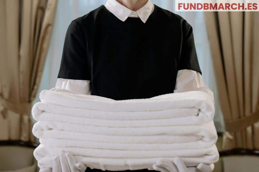 Person Holding a Stack of White Towels